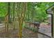 Decking area with outdoor grill and lounge setting surrounded by beautiful mature trees at 5179 Poplar Glen Dr, Matthews, NC 28104