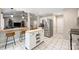 Bright kitchen with stainless steel appliances, tile flooring, wooden breakfast bar with chairs, and an open floorplan to the living room at 5179 Poplar Glen Dr, Matthews, NC 28104