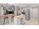 Bright kitchen with stainless steel appliances, tile flooring, wooden breakfast bar with chairs, and an open floorplan to the living room at 5179 Poplar Glen Dr, Matthews, NC 28104
