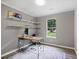 Bright office space with built-in shelving, desk, and large window providing natural light at 5179 Poplar Glen Dr, Matthews, NC 28104