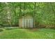 Storage shed in the backyard surrounded by lush greenery and beautiful landscaping at 5179 Poplar Glen Dr, Matthews, NC 28104