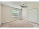 This bedroom features a ceiling fan, neutral carpet, and window with blinds for natural light at 5817 Rocky Mount Ct, Charlotte, NC 28214