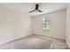 This bedroom features a ceiling fan, neutral carpet, and window with blinds for natural light at 5817 Rocky Mount Ct, Charlotte, NC 28214
