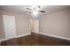 Spacious bedroom with hardwood floors and a ceiling fan features adjacent closets and entryways at 601 N Johnson St, Monroe, NC 28112