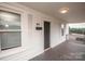 Inviting covered front porch with gray stained wood decking, and white painted wood walls and trim at 601 N Johnson St, Monroe, NC 28112