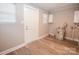 Functional utility room with white door, water heater, and a window with durable vinyl flooring at 601 N Johnson St, Monroe, NC 28112