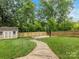 Lush backyard featuring a basketball court, garden shed, wood fence, and a neatly landscaped lawn at 612 Ideal Way, Charlotte, NC 28203