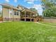 Spacious backyard featuring a large covered deck, lush lawn, and a privacy fence at 612 Ideal Way, Charlotte, NC 28203