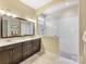 Bright bathroom featuring a double sink vanity, tiled floors, and a spacious glass-enclosed shower at 612 Ideal Way, Charlotte, NC 28203