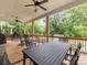 Spacious covered deck featuring a dining table with black chairs, rocking chairs, and ceiling fans at 612 Ideal Way, Charlotte, NC 28203