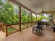 Comfortable covered deck with ceiling fans, rocking chairs, and outdoor dining table overlooking a wooded area at 612 Ideal Way, Charlotte, NC 28203