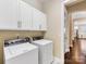 Clean and functional laundry room equipped with modern washer and dryer, white cabinets, and bright lighting at 612 Ideal Way, Charlotte, NC 28203
