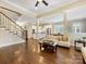 Bright living room showcasing hardwood floors, a staircase, and seamlessly connected to the kitchen and dining area at 612 Ideal Way, Charlotte, NC 28203