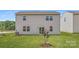 A rear view of the home with a grassy yard and small tree in the back at 6331 Fairfax Ct, Maiden, NC 28650