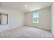 This bedroom is bright, featuring a neutral carpet, a window, and an ensuite doorway at 6331 Fairfax Ct, Maiden, NC 28650