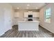 Modern kitchen featuring a large island, white cabinets, and stainless steel appliances at 6331 Fairfax Ct, Maiden, NC 28650