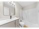 Modern bathroom with grey vanity, square mirror, and a shower-tub combo at 6340 Green Vista Ct, Charlotte, NC 28212