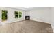 Spacious living room with wood floors and a cozy fireplace offering serene views of the backyard at 6340 Green Vista Ct, Charlotte, NC 28212