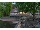 Waterfront home with a wooden dock, stone facade, and covered deck offering picturesque lakeside living at 639 Panther Point Trl, Richfield, NC 28137