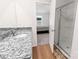 This bathroom features luxury vinyl flooring, a granite countertop, and a shower at 672 Lamorak Pl, Richburg, SC 29729