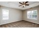 A serene bedroom featuring a ceiling fan, plush carpeting, and natural light from multiple windows at 676 Rebecca Jane Dr, Mooresville, NC 28115
