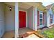 Close-up of the front door with red finish, sidelight, and classic exterior lighting at 676 Rebecca Jane Dr, Mooresville, NC 28115