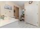 Bright bathroom with double door closet, white tile floor, sink, and convenient towel storage at 7430 Forney Hill Rd, Denver, NC 28037