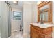 Well-lit bathroom with a decorative wood vanity, framed mirror and a tiled floor at 7430 Forney Hill Rd, Denver, NC 28037