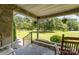 Inviting front porch with stone flooring, hanging plants, and cozy seating, perfect for relaxing outdoors at 7430 Forney Hill Rd, Denver, NC 28037
