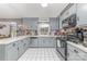 Galley kitchen featuring gray cabinets, stainless steel appliances, and tile floors at 7430 Forney Hill Rd, Denver, NC 28037