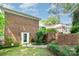 Backyard view featuring an exterior door, brick, lush landscaping, and inviting outdoor space at 935 Trentle Ct, Charlotte, NC 28211