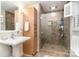 Bathroom featuring tiled shower with glass enclosure, a pedestal sink, and wooden storage at 935 Trentle Ct, Charlotte, NC 28211