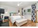 Cozy bedroom with a king bed, white bedding, bench, and modern decor, illuminated by natural light at 935 Trentle Ct, Charlotte, NC 28211