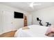 Minimalist bedroom featuring a king bed, ceiling fan, mounted TV, and access to another room at 935 Trentle Ct, Charlotte, NC 28211