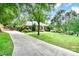 Brick home with a long driveway, mature trees and a beautifully landscaped lawn with manicured garden beds at 935 Trentle Ct, Charlotte, NC 28211