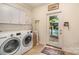 Functional laundry room with modern washer/dryer, ample storage, and convenient pool access at 935 Trentle Ct, Charlotte, NC 28211