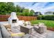 Inviting backyard patio with outdoor fireplace, comfortable seating, and manicured lawn at 1008 Vanizer St, Charlotte, NC 28208