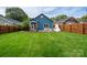 Spacious backyard featuring a well-maintained lawn, privacy fence, and an inviting outdoor fireplace at 1008 Vanizer St, Charlotte, NC 28208