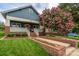 Charming blue home featuring a welcoming porch, brick accents, an orange front door, and a beautiful flowering tree at 1008 Vanizer St, Charlotte, NC 28208