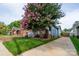 Charming blue home featuring a welcoming porch, brick accents, an orange front door, and a beautiful flowering tree at 1008 Vanizer St, Charlotte, NC 28208