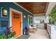 Inviting front porch featuring a swing, an orange front door, and stylish lighting fixtures at 1008 Vanizer St, Charlotte, NC 28208