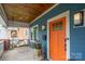 Inviting front porch featuring a swing, an orange front door, and stylish lighting fixtures at 1008 Vanizer St, Charlotte, NC 28208