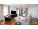 Comfortable living room featuring hardwood floors, ample seating, a modern chandelier, and bright windows at 1008 Vanizer St, Charlotte, NC 28208