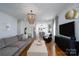Spacious living room featuring hardwood floors, ample seating, a modern chandelier, and access to kitchen at 1008 Vanizer St, Charlotte, NC 28208