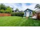 Backyard shed with a white door, complemented by lush greenery and a cozy hanging chair at 1008 Vanizer St, Charlotte, NC 28208