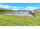 Community pool with multiple lounge chairs and umbrellas, surrounded by a fence and lush green landscaping at 103 Blackstone Ct # C, Statesville, NC 28677