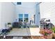 Back patio with an outdoor table, chairs, string lights, potted plants, and grill at 103 Blackstone Ct # C, Statesville, NC 28677