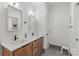 Bathroom with wood cabinets, double sinks, modern fixtures, and walk-in shower at 113 Prince St, Belmont, NC 28012
