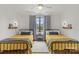 A spacious bedroom featuring two twin beds, light hardwood floors, and outdoor views at 113 Prince St, Belmont, NC 28012