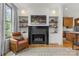 Cozy living room with a fireplace, built-in shelving, and natural light streaming through the window at 113 Prince St, Belmont, NC 28012